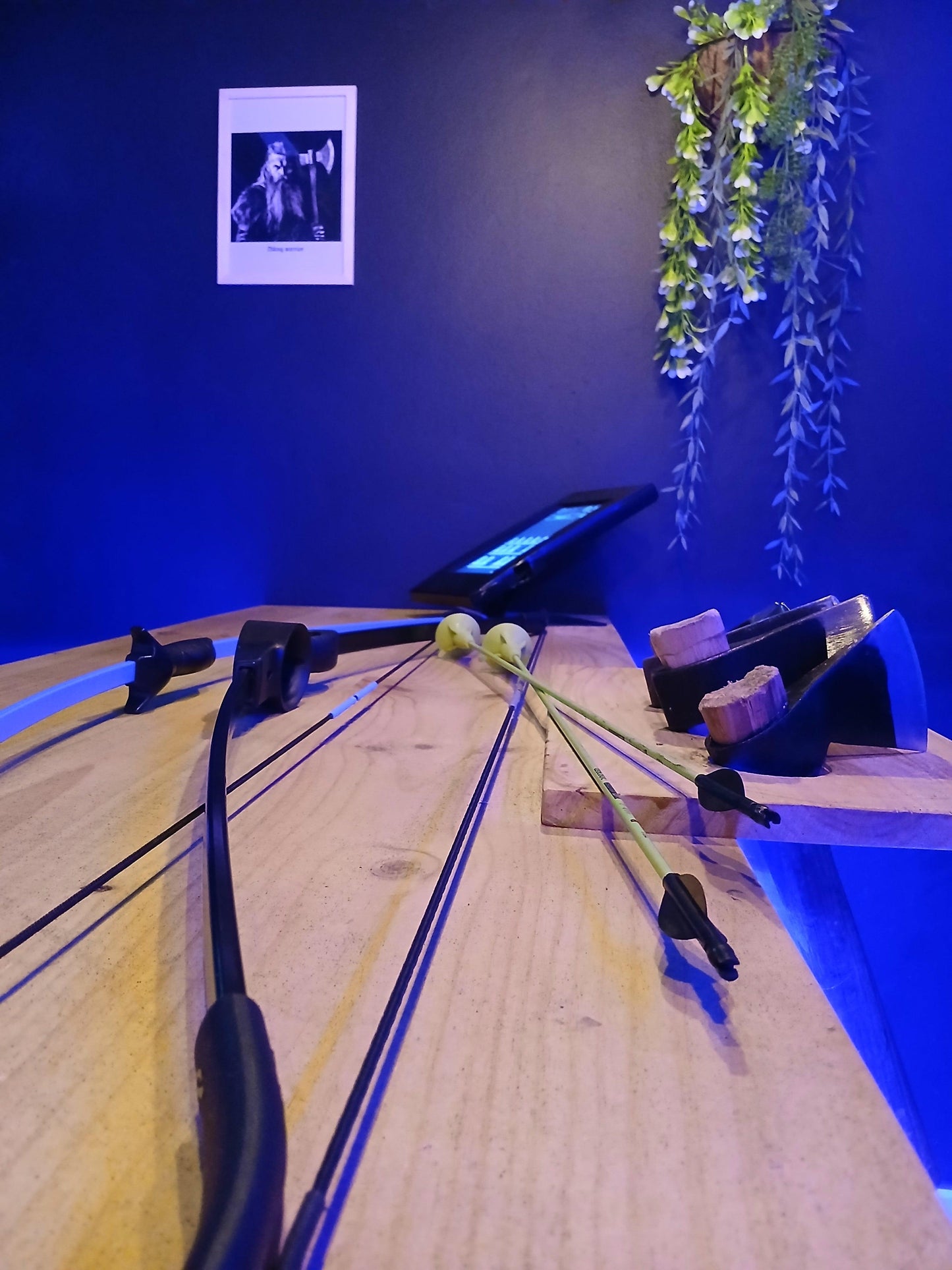 A young child aiming at an interactive target with a suction cup bow during a family-friendly activity at Axe Throwing Tenerife.