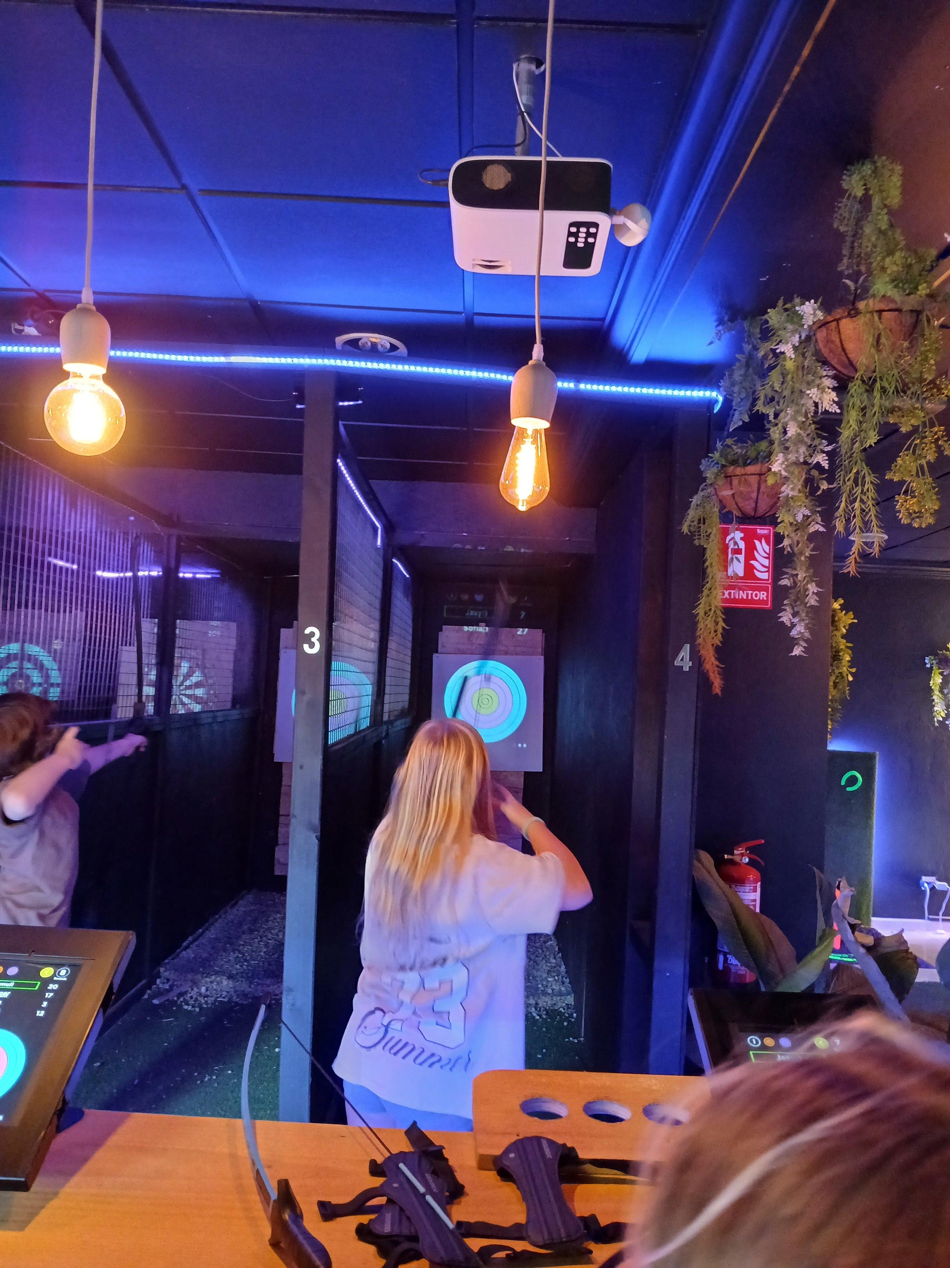 A child playing on an interactive digital target, enjoying one of the 17 fun games available at Axe Throwing Tenerife.

