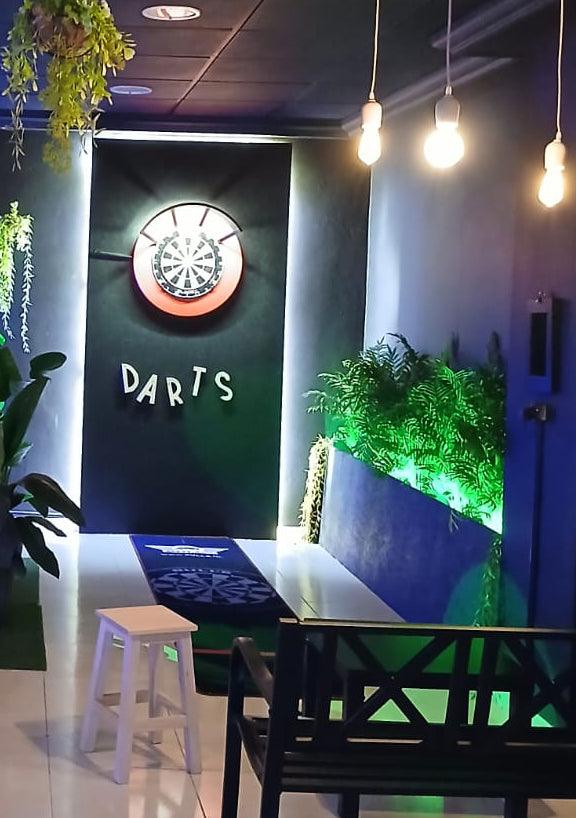 A player aiming at a professional dartboard on a dedicated lane in Playa Las Américas, Tenerife. Perfect for competitive matches and group fun.