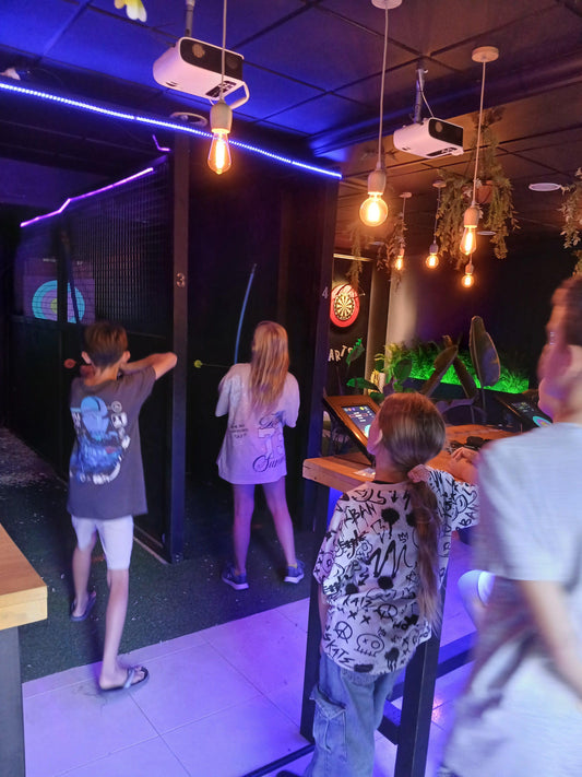 A group of children learning how to throw axes under expert supervision in Playa Las Américas, Tenerife. A safe and exciting birthday activity!

