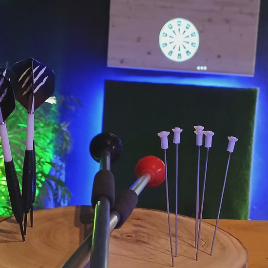  A player aiming at a digital projection dartboard in Playa Las Américas, enjoying the immersive Pixels Darts experience in Tenerife.