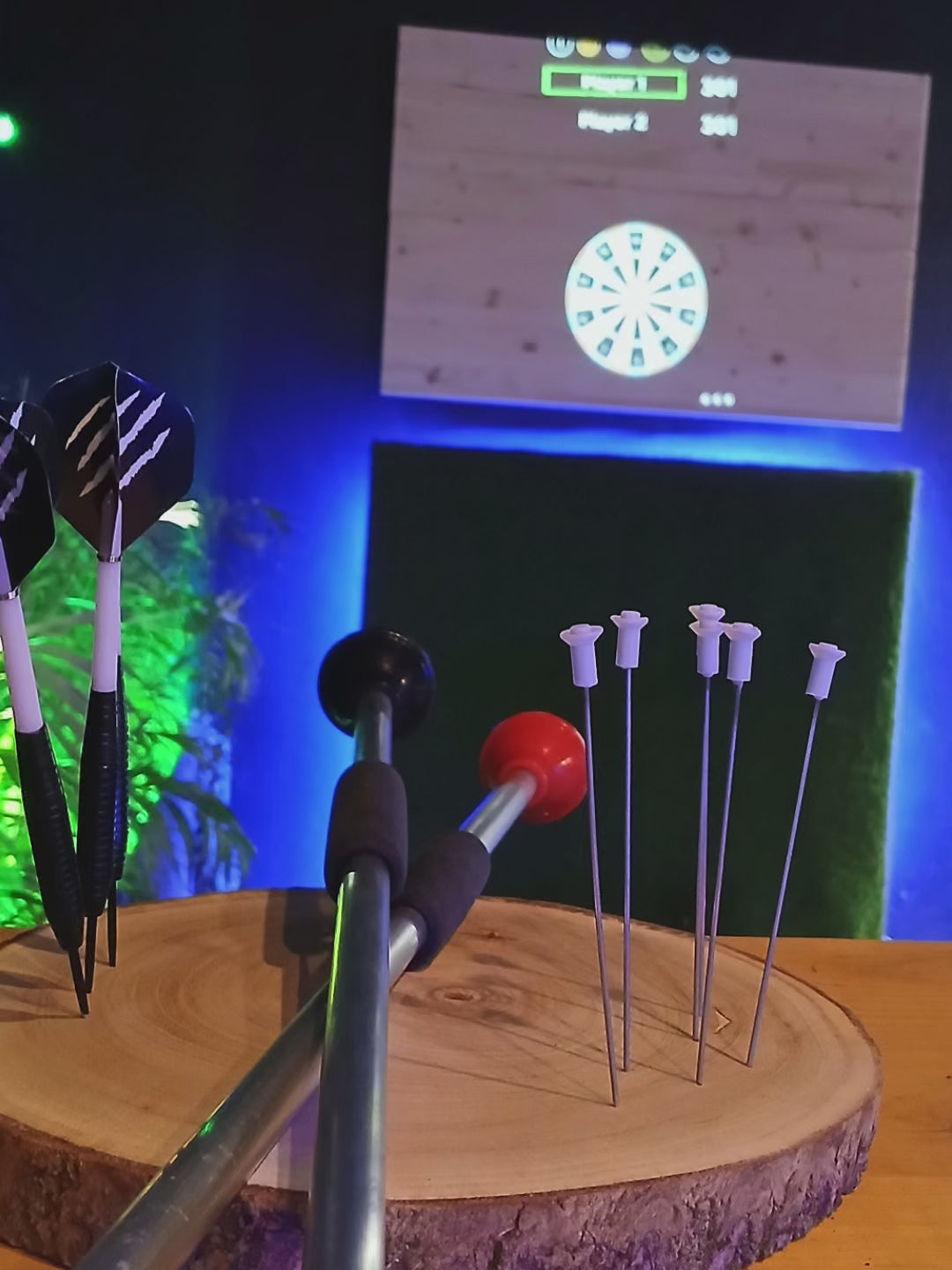  A player aiming at a digital projection dartboard in Playa Las Américas, enjoying the immersive Pixels Darts experience in Tenerife.